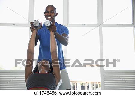 Personal trainer and client training with dumbbells View Large Photo Image Stock Photograph - Personal trainer and client training with dumbbells. Fotosearch