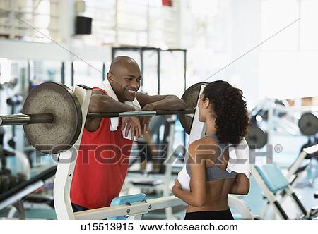Stock Photography - Woman and man talking in gym. Fotosearch
