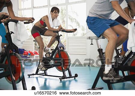 Stock Photograph - Woman indoor cycling. Fotosearch