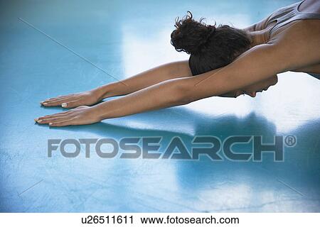 Stock Image - Woman stretching (high angle view). Fotosearch
