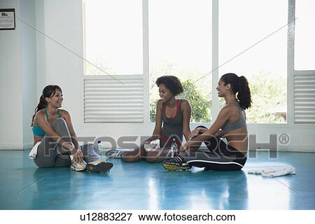 Stock Photo - Women in sports clothing sitting on floor. Fotosearch