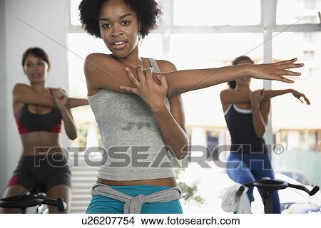 Picture - Women stretching on exercise bikes. Fotosearch
