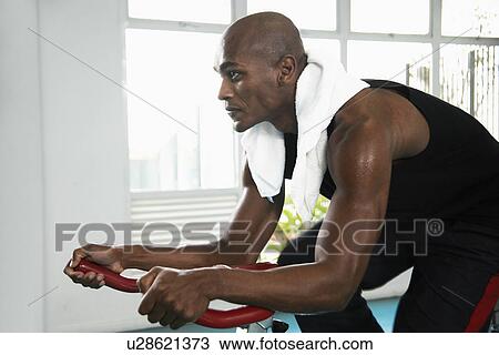 Young man indoor cycling View Large Photo Image Stock Image - Young man indoor cycling. Fotosearch