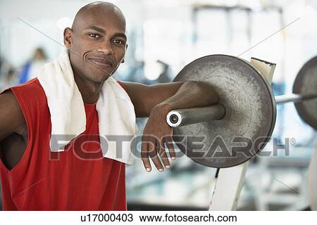 Young man leaning against barbell (portrait) View Large Photo Image Stock Image - Young man leaning against barbell (portrait). Fotosearch