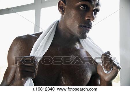 Stock Image - Young man with towel around neck. Fotosearch