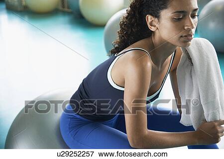 Young woman sitting on Swiss ball View Large Photo Image Stock Photo - Young woman sitting on Swiss ball. Fotosearch