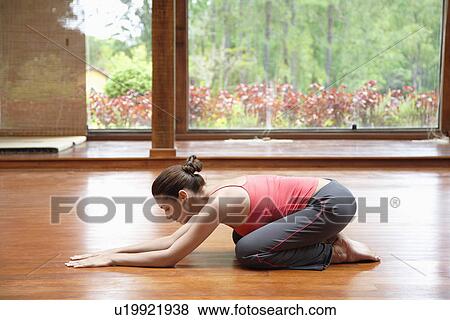 Young woman stretching on wooden floor View Large Photo Image Stock Photo - Young woman stretching on wooden floor. Fotosearch