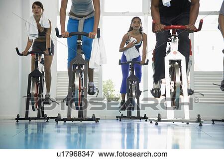 Young women indoor cycling View Large Photo Image Stock Photo - Young women indoor cycling. Fotosearch