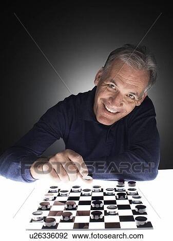Man moving checker piece View Large Photo Image Stock Image - Man moving checker piece. Fotosearch
