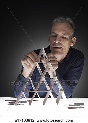 Mature man building house of cards View Large Photo Image Stock Image - Mature man building house of cards. Fotosearch
