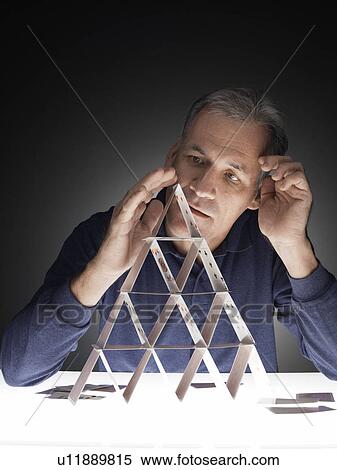 Mature man building house of cards View Large Photo Image Stock Photography - Mature man building house of cards. Fotosearch