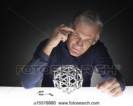 Mature man building polyhedron View Large Photo Image Stock Image - Mature man building polyhedron. Fotosearch