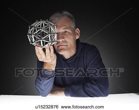 Mature man holding polyhedron View Large Photo Image Stock Photograph - Mature man holding polyhedron. Fotosearch