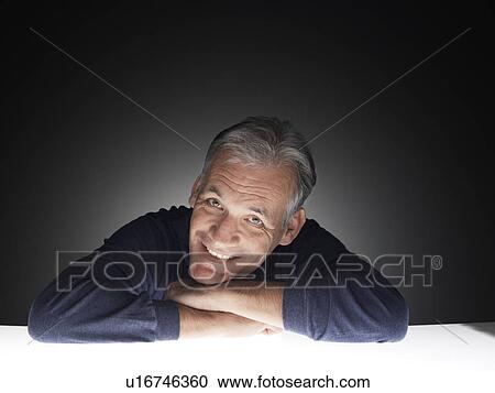 Mature man leaning on table and laughing (portrait) View Large Photo Image Stock Image - Mature man leaning on table and laughing (portrait). Fotosearch