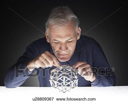 Mature man playing with puzzle View Large Photo Image Stock Photo - Mature man playing with puzzle. Fotosearch