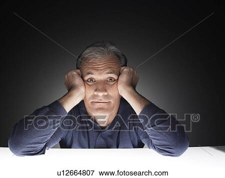 Stock Photo - Mature man with head in hands (portrait). Fotosearch