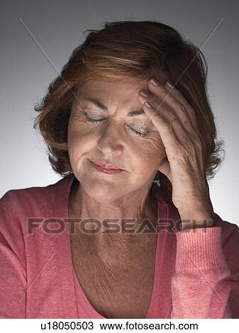 Stock Image - Mature woman with headache. Fotosearch