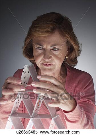 Woman building house of cards View Large Photo Image Stock Photography - Woman building house of cards. Fotosearch