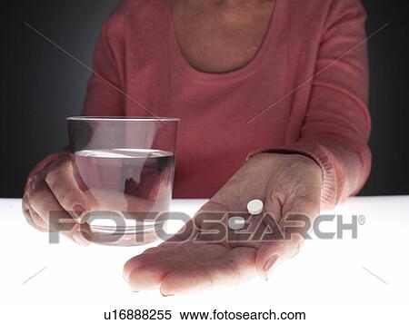 Woman holding pills and glass of water (close-up) View Large Photo Image Stock Photography - Woman holding pills and glass of water (close-up). Fotosearch