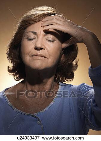 Stock Photo - Woman rubbing forehead. Fotosearch