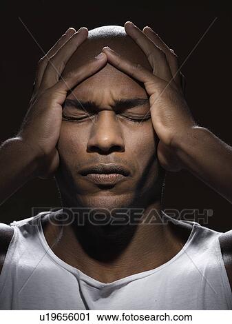 Young man holding his head View Large Photo Image Stock Image - Young man holding his head. Fotosearch