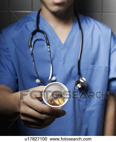 Stock Image - Doctor Showing Pills. Fotosearch