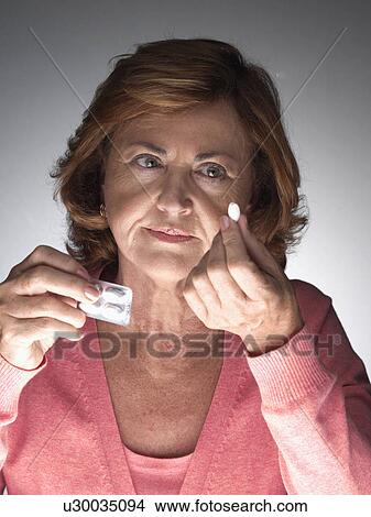 Mature woman taking aspirin View Large Photo Image Picture - Mature woman taking aspirin. Fotosearch