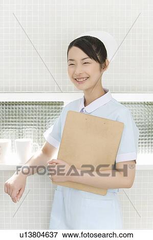 Portrait of a nurse holding a clipboard, smiling, front view View Large Photo Image Stock Photo - Portrait of a nurse holding a clipboard, smiling, front view. Fotosearch