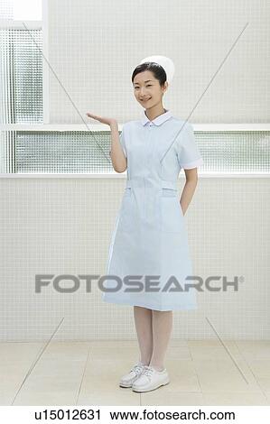 Stock Image - Portrait of a nurse, smiling and looking at camera, front view. Fotosearch