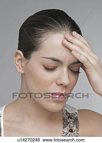Young woman with hand on forehead View Large Photo Image Stock Photograph - Young woman with hand on forehead. Fotosearch