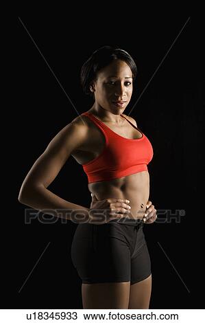 Stock Image - African American young adult woman in athletic apparel with hands on hips.. Fotosearch