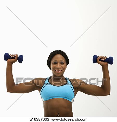 African American young adult woman raising dumbbells over head and smiling at viewer. View Large Photo Image Stock Image - African American young adult woman raising dumbbells over head and smiling at viewer.. Fotosearch
