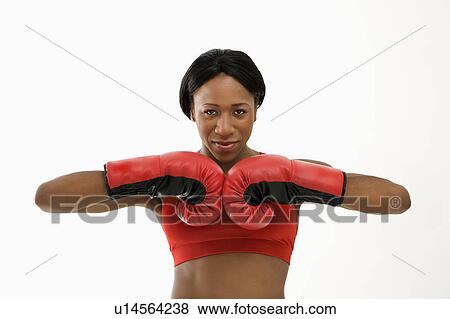 Stock Photo - African American young adult woman wearing boxing goves with fists together.. Fotosearch