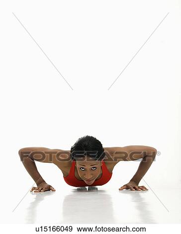 Stock Photo - African American young adult woman doing push up and looking at viewer.. Fotosearch