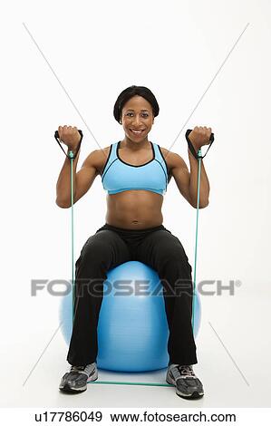 African American young adult woman sitting on exercise ball using resistance tube. View Large Photo Image Stock Photo - African American young adult woman sitting on exercise ball using resistance tube.. Fotosearch