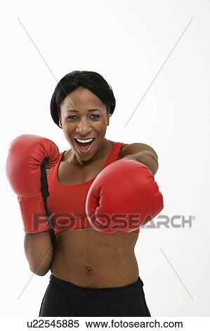 Stock Photography - African American young adult woman wearing boxing goves throwing playful punch at viewer.. Fotosearch