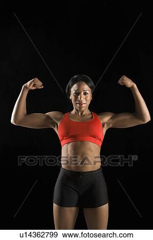 Muscular African American woman wearing athletic apparel with biceps flexed. View Large Photo Image Stock Photo - Muscular African American woman wearing athletic apparel with biceps flexed.. Fotosearch