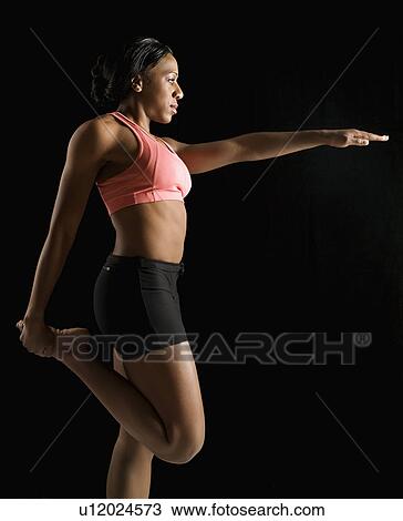 Profile of African American young adult woman stretching leg with arm raised. View Large Photo Image Stock Image - Profile of African American young adult woman stretching leg with arm raised.. Fotosearch