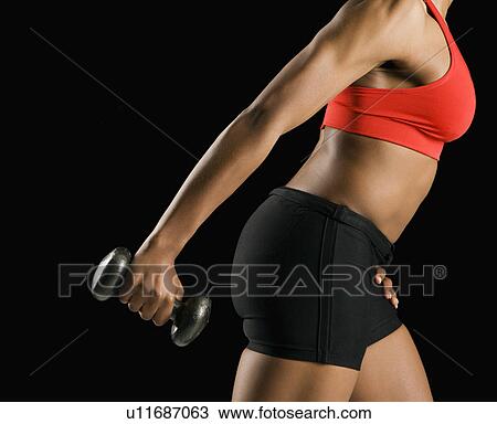 Side view if torso of African American young adult woman holding dumbbell outstretched. View Large Photo Image Stock Image - Side view if torso of African American young adult woman holding dumbbell outstretched.. Fotosearch