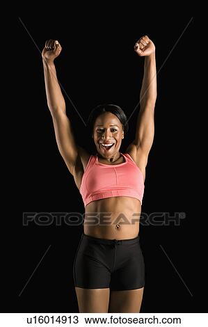 Smiling African American young adult woman in athletic apparel stretching arms above head. View Large Photo Image Stock Image - Smiling African American young adult woman in athletic apparel stretching arms above head.. Fotosearch