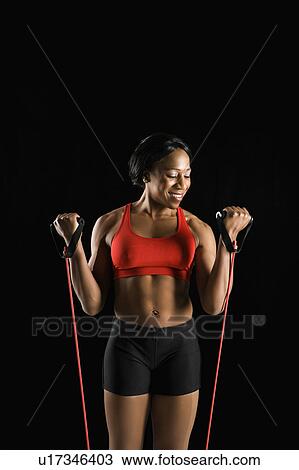 Smiling African American young adult woman exercising with resistance tube. View Large Photo Image Stock Image - Smiling African American young adult woman exercising with resistance tube.. Fotosearch