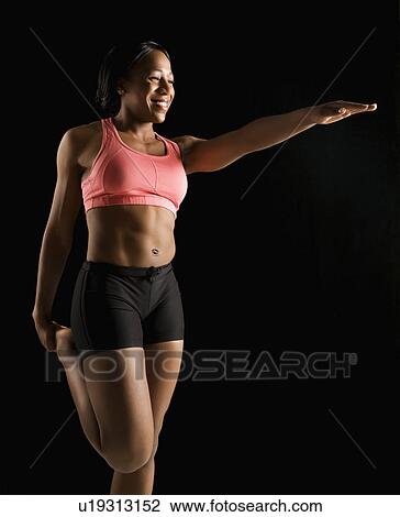 Smiling African American young adult woman standing and stretching. View Large Photo Image Stock Image - Smiling African American young adult woman standing and stretching.. Fotosearch