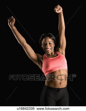 Smiling African American young adult woman in sports bra stretching arms above head. View Large Photo Image Stock Photo - Smiling African American young adult woman in sports bra stretching arms above head.. Fotosearch