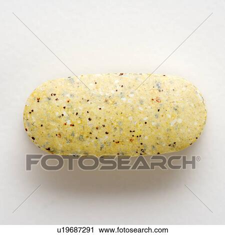 Stock Image - Close up of brown speckled caplet against white background.. Fotosearch