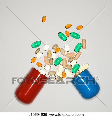 Stock Photograph - Container with spilt pills and vitamins.. Fotosearch