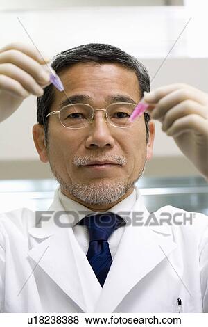 Mature scientist man looking at test tubes in laboratory, front view View Large Photo Image Stock Photo - Mature scientist man looking at test tubes in laboratory, front view. Fotosearch