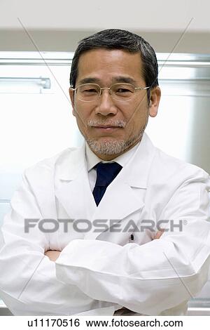 Stock Photograph - Portrait of a mature scientist man in laboratory, front view. Fotosearch