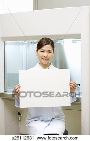 Portrait of a young scientist woman holding a white board, front view View Large Photo Image Stock Image - Portrait of a young scientist woman holding a white board, front view. Fotosearch
