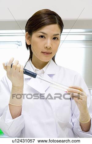 Portrait of a young scientist woman injecting liquid into a test tube in laboratory, front view View Large Photo Image Stock Photo - Portrait of a young scientist woman injecting liquid into a test tube in laboratory, front view. Fotosearch