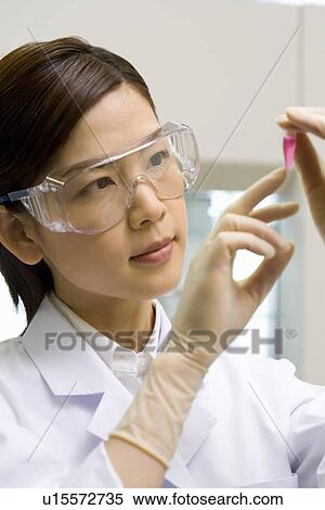 Young scientist woman looking at a test tube in laboratory, wearing a protective eyewear, front view View Large Photo Image Stock Photography - Young scientist woman looking at a test tube in laboratory, wearing a protective eyewear, front view. Fotosearch